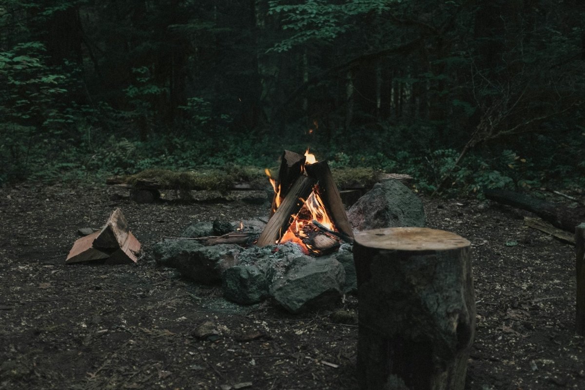 Friends gathering around a cozy outdoor fire pit on an autumn evening