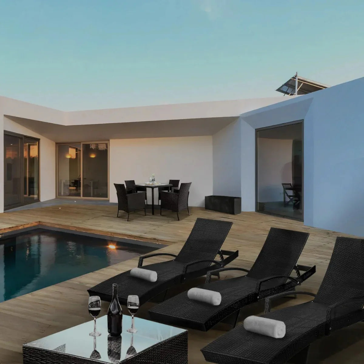 Modern patio with lounge chairs, dining table, and pool area.